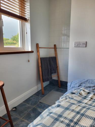 a bedroom with a bed and a window at The Boat House in Adrigole