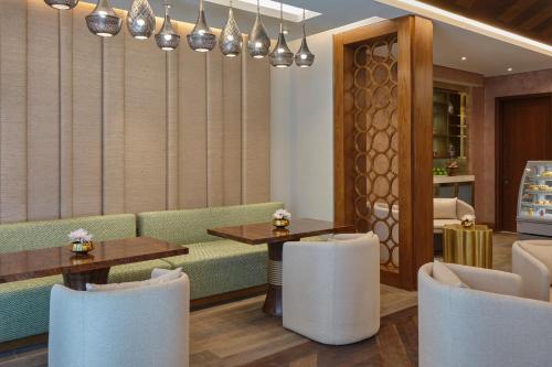 a restaurant with a couch and tables and chairs at Hilton Cairo Nile Maadi in Cairo