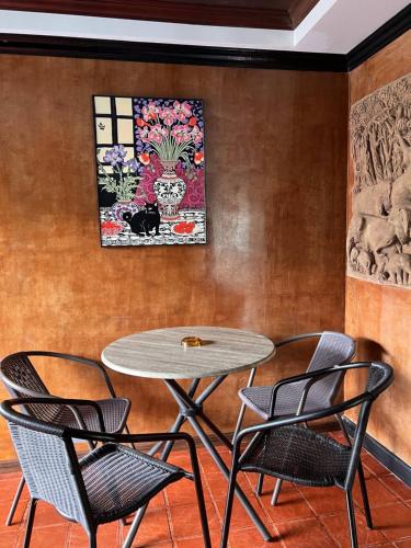 a table and chairs in front of a wall at Baankasemsuk Resort 般咔 深宿 in Patong Beach