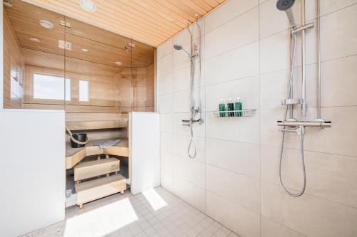 a bathroom with a shower with white tiles at Penthouse Valsa in Rovaniemi