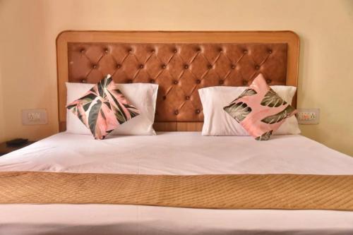 a bed with a headboard and two pillows on it at The Boho near Mall in Shimla