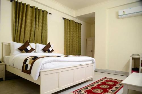 a bedroom with a white bed and green curtains at Hotel Dior Near Jal Mahal, Jaipur in Jaipur