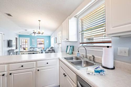 una cucina con mobili bianchi e un lavandino di Surfside Cottage - Charming Quiet 3BD 2BA House - Private Beach Access, Close to Navarre Beach & Gulf Breeze Zoo a Gulf Breeze