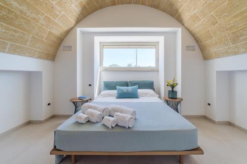 Un dormitorio con una cama con toallas. en VILLA FLORI', en Marina di Pescoluse