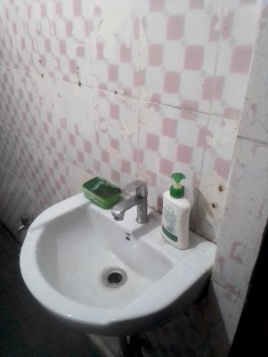 a bathroom sink with a bottle of soap on it at Himalayan Mountain View, Triund Trekking Hostel in Dharamshala