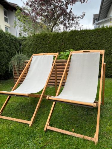 two lawn chairs sitting on the grass in a yard at Ferienwohnung Familiengarten in Volders