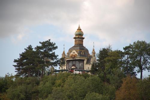 a building with a clock tower on top of trees at Apartmany Chodov in Prague