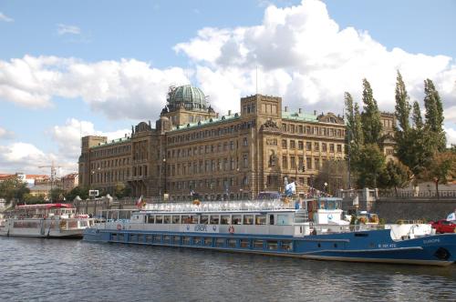 two boats in the water in front of a large building at Apartmany Chodov in Prague