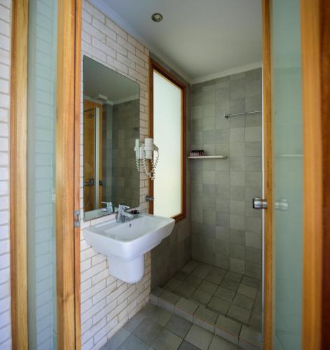a bathroom with a sink and a mirror at Afroditi Venus Beach Resort in Kamari