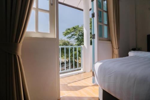 a bedroom with a bed and an open door to a balcony at B&B Chiangrai in Chiang Rai