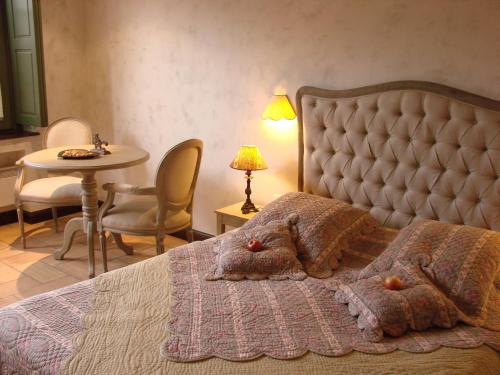 1 dormitorio con 1 cama, mesa y sillas en Les Demoiselles de Ladoix, en Ladoix Serrigny