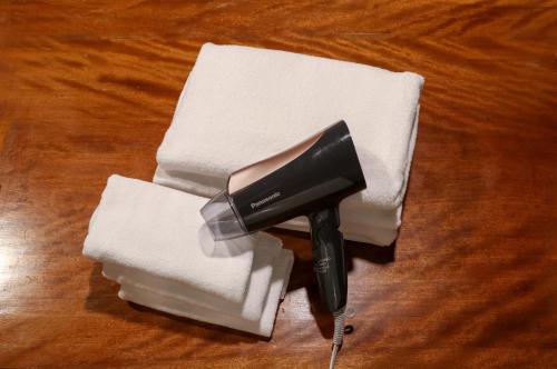 a hair dryer sitting on top of a pile of towels at Souwaan in Takayama