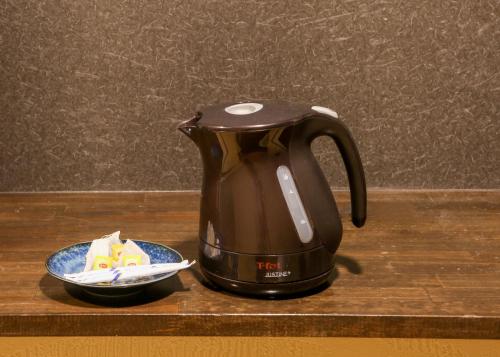 a black tea kettle sitting on a counter with a plate at Souwaan in Takayama