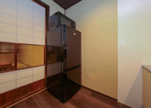 a large black refrigerator in a room at Souwaan in Takayama