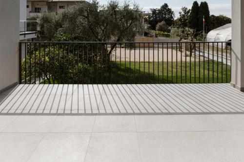 a black fence with a tile floor in front at Residence Piccolo Olimpo in Toscolano Maderno