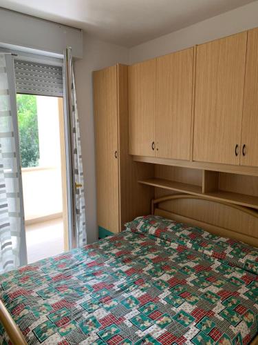 a bedroom with a bed with a quilt on it at Beautifully renovated flat with shared pool in Rosolina Mare