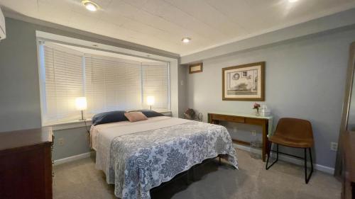 a bedroom with a bed and a desk and a window at Near downtown with hot tub sleeps seven in Blacksburg