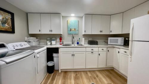 a kitchen with white cabinets and a white refrigerator at Near downtown with hot tub sleeps seven in Blacksburg