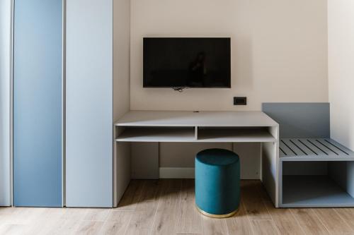 a white desk with a tv on a wall at Residence Piccolo Olimpo in Toscolano Maderno