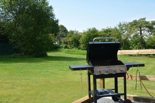 a barbecue grill sitting on a table in a yard at Tree Tops in Lulsgate Bottom
