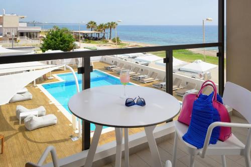 a balcony with a table and chairs and a view of the ocean at SESA Boutique Hotel & Restaurant in Kanali