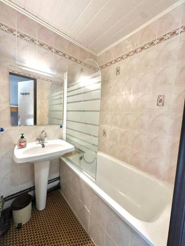 une salle de bain avec un lavabo et une baignoire dans l'établissement Studio 121 Canet Plage, à Canet