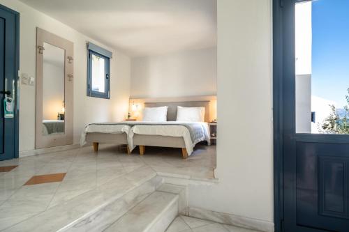 a bedroom with a bed and a large window at Porto Galini Seaside Resort & Spa in Nikiana