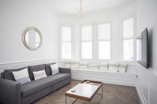 a living room with a couch and a table at Coachman's Cottage in Worthing