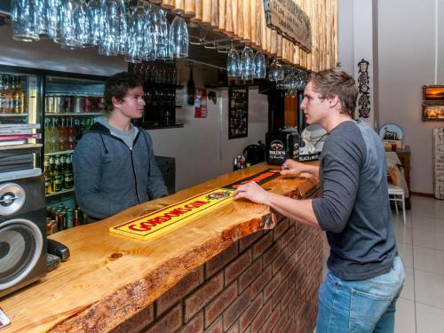 two men standing at a counter in a bar at The Comfort Zone - Mthatha in Mthatha