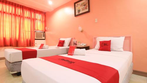 two beds in a room with red and white at RedDoorz Plus @ Chinatown Binondo in Manila