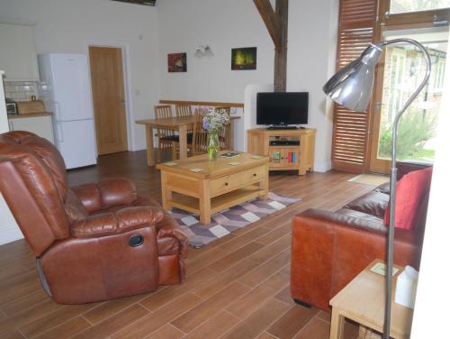 a living room with a couch and a table at 2 Moatside Cottages in Hassocks