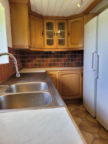 a kitchen with a sink and a refrigerator at Storstugan nära havet in Ystad