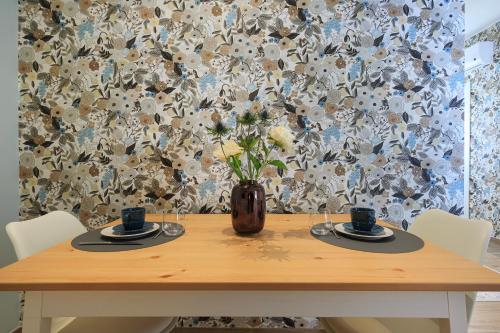 a wooden table with a vase with flowers on it at Il Giuelìn Malpensa B&B in Case Nuove