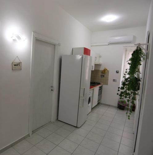 a kitchen with a white refrigerator in a room at HOUSE 27 in Fiumicino