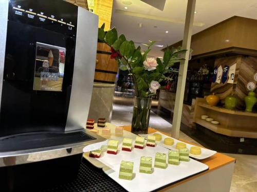 a counter with a vase of flowers and medicines at Li Cai Tian Qi Hotel Xianyang in Xianyang