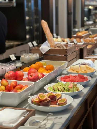 a buffet line with many plates of fruit and vegetables at Li Cai Tian Qi Hotel Xianyang in Xianyang