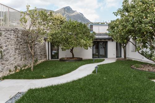 a house with a garden and a stone wall at Residence Piccolo Olimpo in Toscolano Maderno