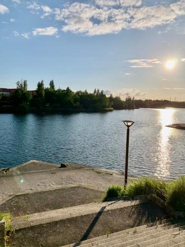 a view of a river with the sun setting at Appartement vue sur Lac proche métro in Créteil