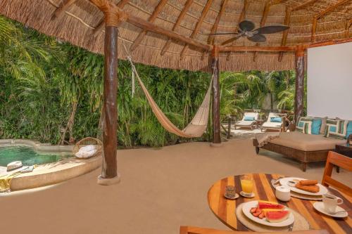 a living room with a hammock and a pool at Viceroy Riviera Maya, a Luxury Villa Resort - Adults Only in Playa del Carmen