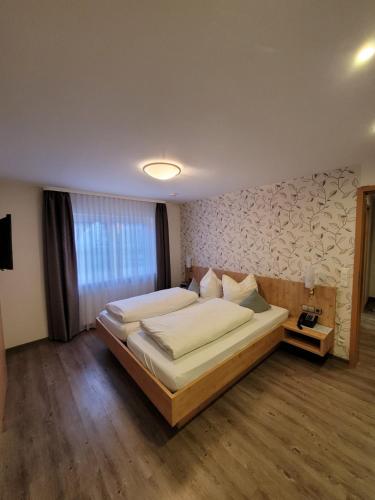 a bedroom with a large bed in a room at Hotel Zur Linde in Lauf