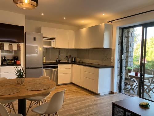 - une cuisine avec une table, une table et des chaises dans l'établissement Villa luxury vue mer au centre-ville de Porto Vecchio, à Porto-Vecchio