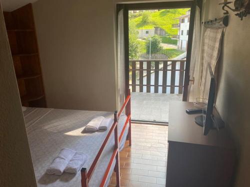 a bedroom with a bed with a view of a porch at Baita vacanze Foppa in Rasura