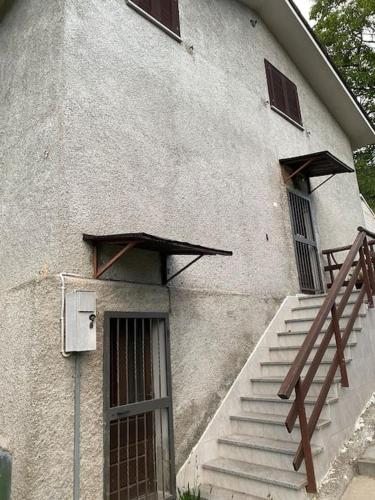 a building with stairs and a door and a stair railing at Baita vacanze Foppa in Rasura