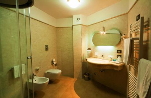 ein Badezimmer mit einem Waschbecken, einem WC und einem Spiegel in der Unterkunft L'Isola Di Aurora in Martirano