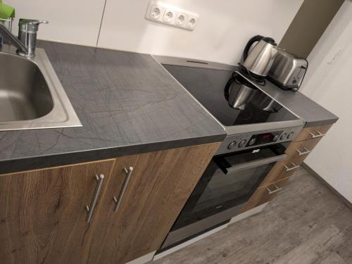 a kitchen with a sink and a stove top oven at NestOaseWHV Zentrale Zimmer zwischen City und Südstrand in Wilhelmshaven