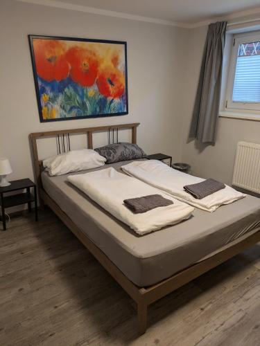 a bed in a bedroom with a painting on the wall at NestOaseWHV Zentrale Zimmer zwischen City und Südstrand in Wilhelmshaven