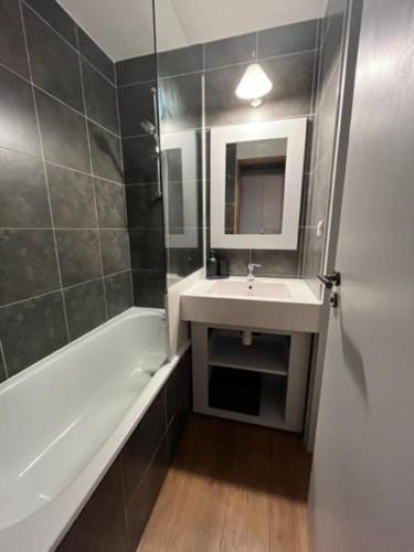 une salle de bain avec un lavabo et une baignoire dans l'établissement Studio 4 personnes Plein Centre, à Huez