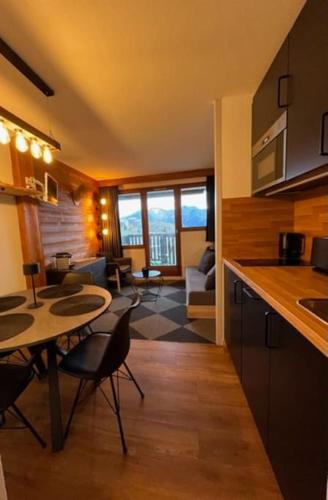 une cuisine et un salon avec une table et des chaises dans l'établissement Studio 4 personnes Plein Centre, à Huez