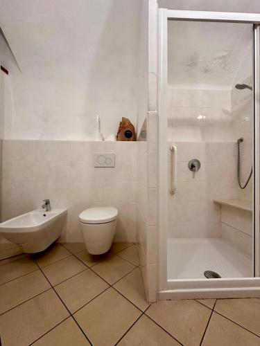 a white bathroom with a toilet and a shower at Casa Vicolo ai Campi in Ardesio