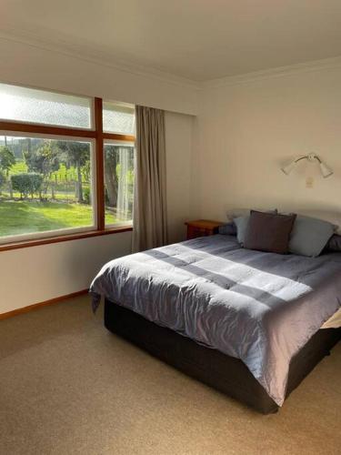 a bedroom with a large bed and a window at River Farm Retreat in Mangaweka